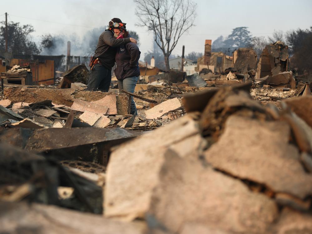 People embrace as they inspect a family member's property that was destroyed by the fires in Altadena, Calif., on Jan. 9, 2025.