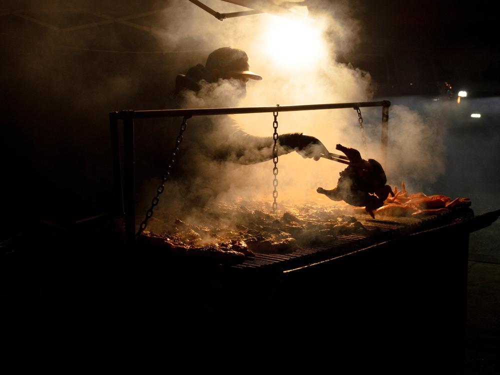 A vendor grills chicken roadside for customers in Fremont, Neb. He says the majority of his customers are from the surrounding Latino community.