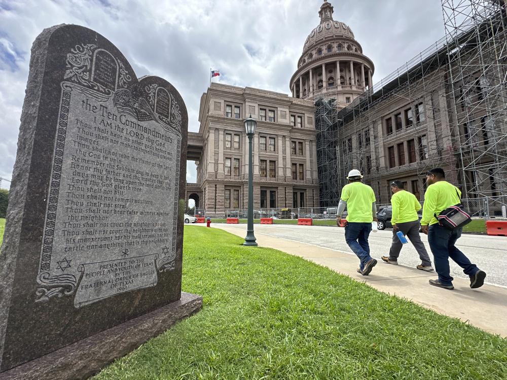 Construction workers walk past a monument with the Ten Commandments outside the Texas Capitol in Austin last year.