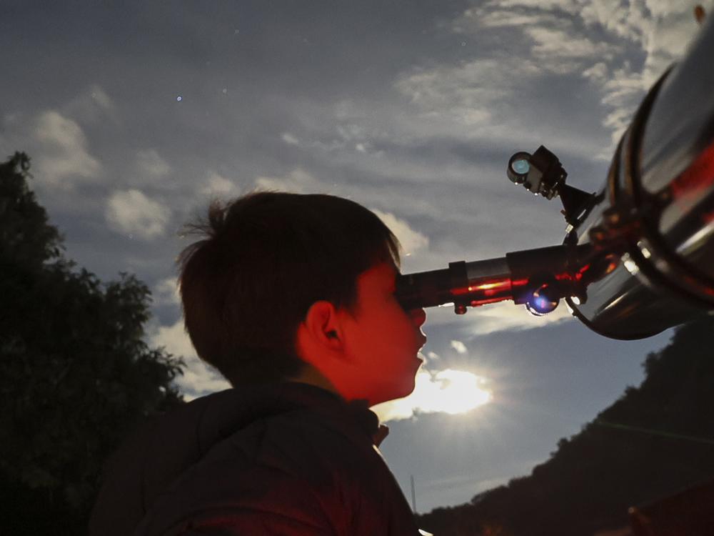 A youth looks through a telescope during a stargazing and comet-watching gathering at Joya-La Barreta Ecological Park in Queretaro, Mexico, on Oct. 19, 2024.