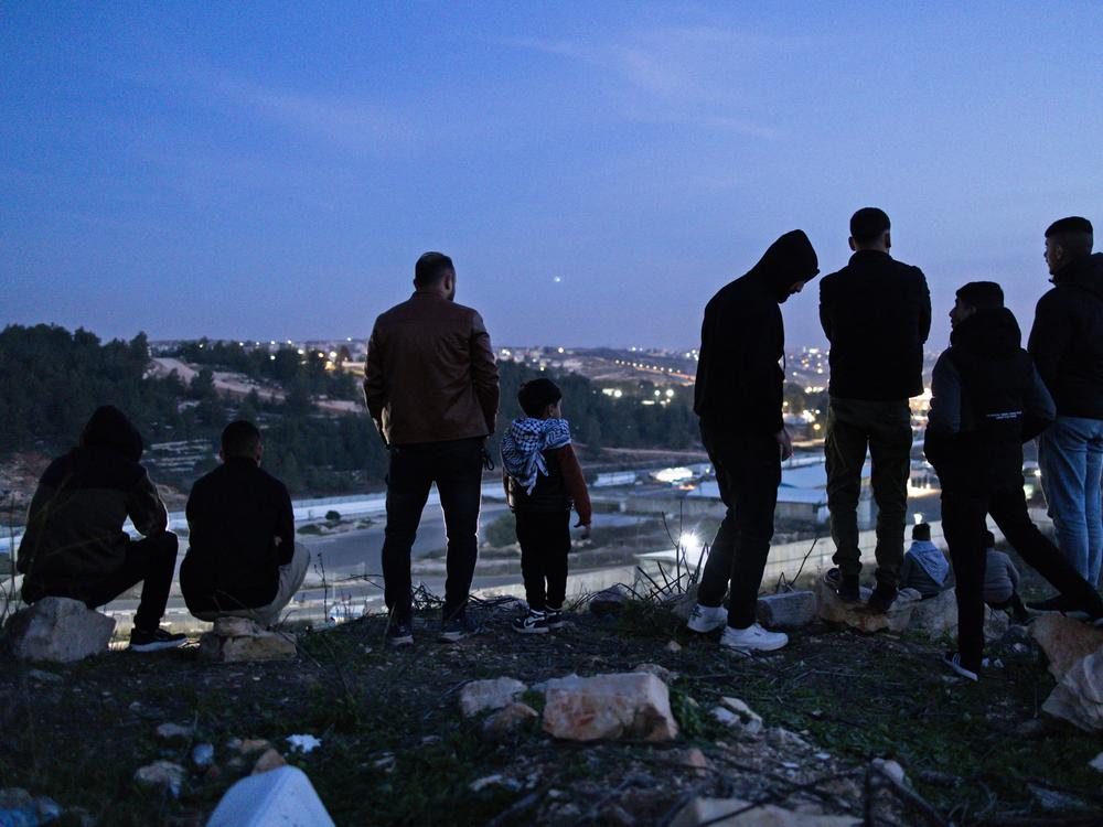 Family members and relatives of Palestinian prisoners, wait for their release, while standing on a hill above the Ofer Prison, in the west of Ramallah on January 19, 2025.