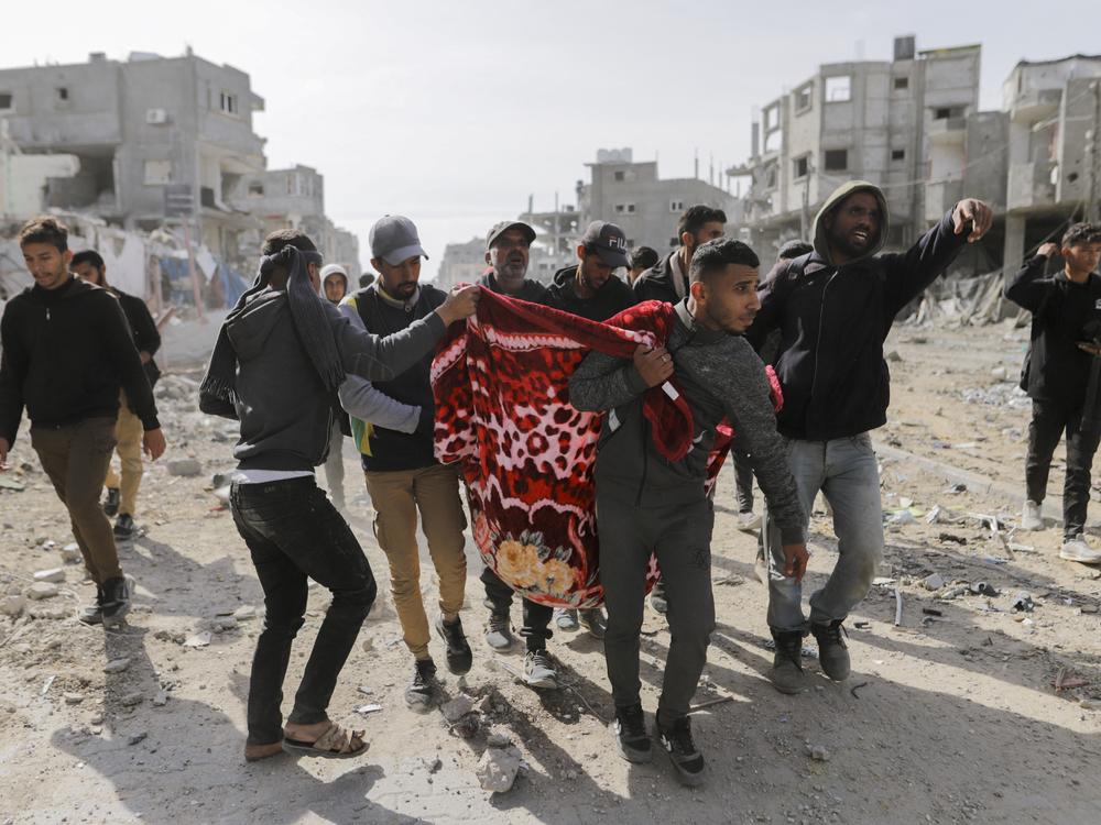 Palestinians carry a wounded man through the streets of Rafah, Gaza Strip, on Jan. 19, 2025.