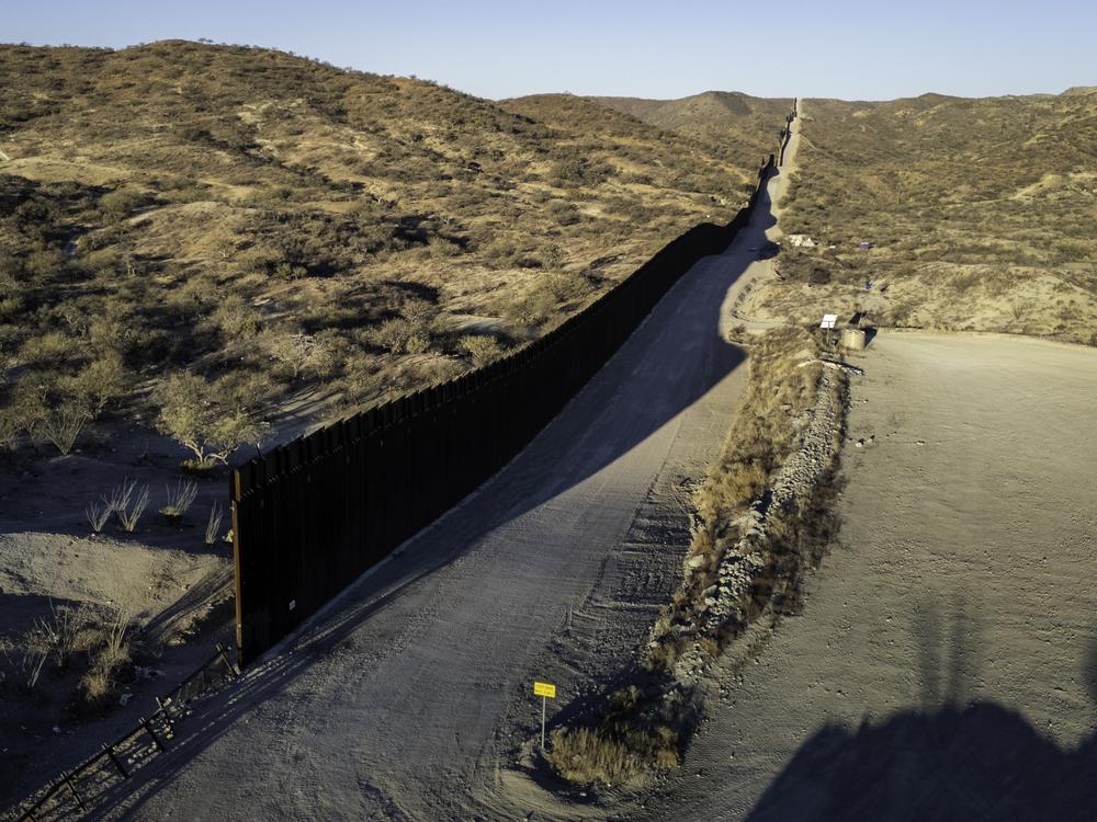 In this aerial view, the U.S.-Mexico border wall ends with a gap on Sunday near Sasabe, Ariz. Although immigrant crossings are down sharply, the incoming Trump administration has vowed to complete the wall and 