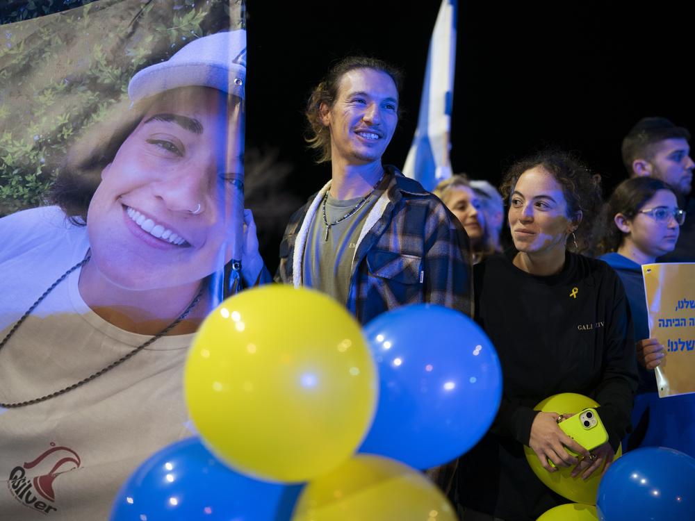 Friends of Emily Damari, hold a sign with her image that reads 'Our Emily, Welcome home, Our hero' on Jan. 19, 2025.