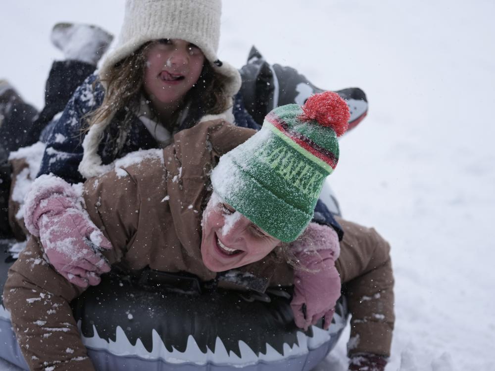 Houston, Texas: Abbie Schuh and her 8-year-old daughter Louise Delisio get covered in snow as they sled down a hill at Herman Park on Jan. 21.