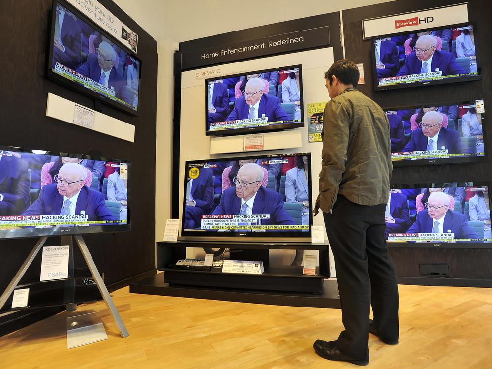 A man watches televisions in a shop in Glasgow, Scotland, on July 19, 2011, showing Rupert Murdoch giving evidence to a British Parliamentary Select Committee on the phone hacking scandal involving his tabloids.