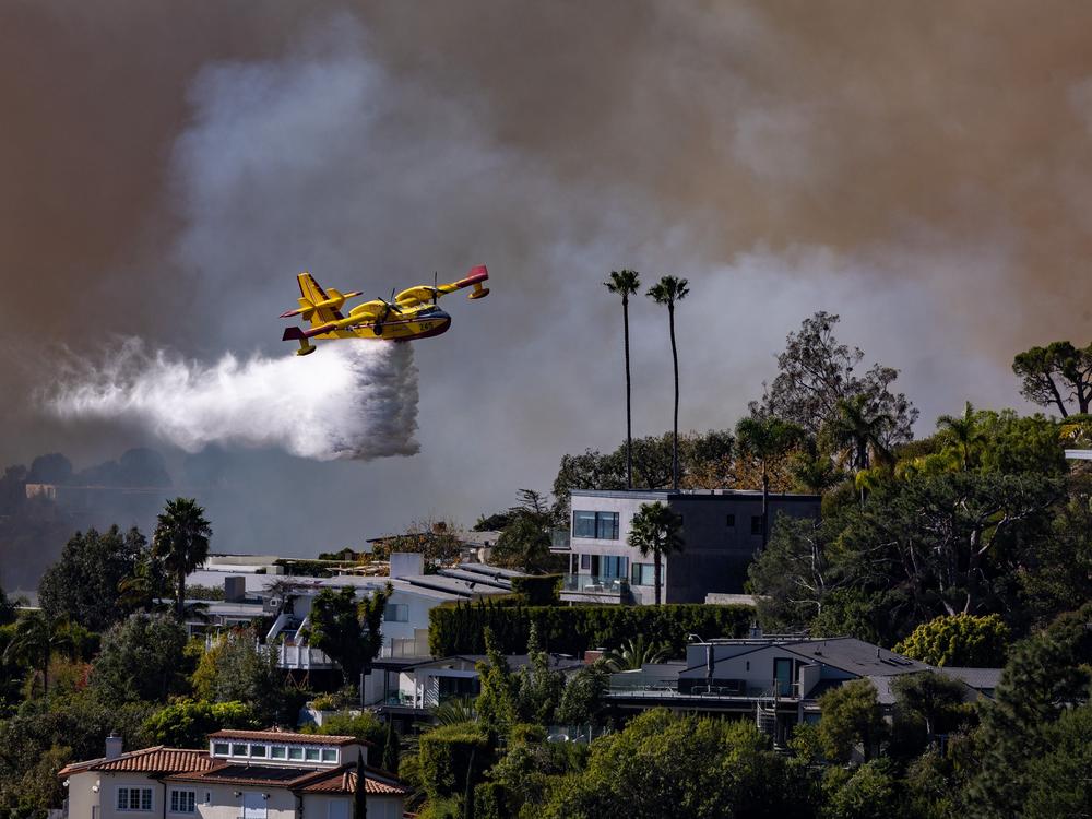 A Super Scooper plane drops water on the Palisades fire on Jan. 7 in Pacific Palisades, Calif.