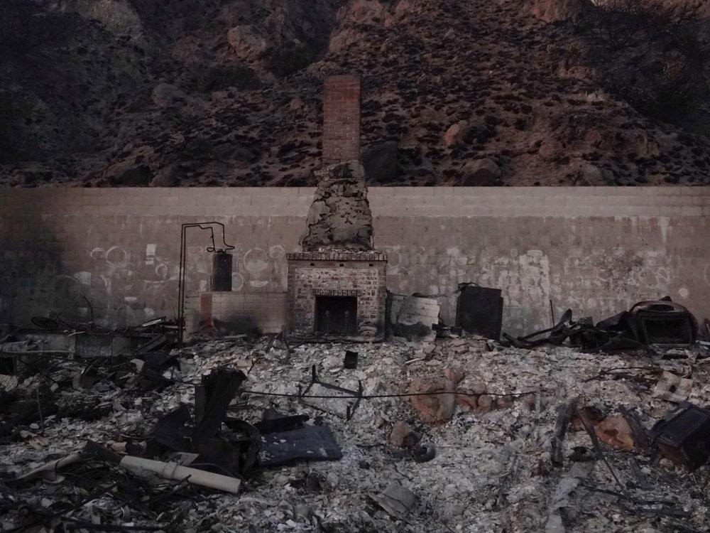A chimney stands against the back wall of a house reduced to ashes in the Palisades Fire in Malibu, California. Experts warn the smoke, ash and debris left after the fires can pose short- and long-term health risks.