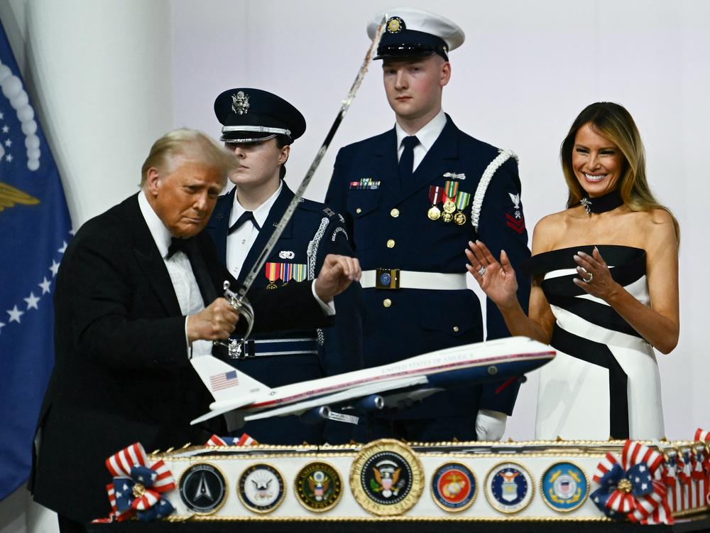 First Lady Melania Trump laughs as she watches President Trump cut with a saber into a cake representation of the new Air Force One design during the Commander-In-Chief inaugural ball at the Walter E. Washington Convention Center in Washington, DC on Monday.