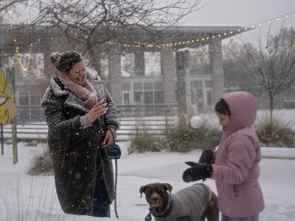 Stephanie Cain, left, and her daughter, Sophia, 6, make snowballs near downtown Houston, as a winter storm brings heavy bands of snow and sleet on Tuesday. Forecasters say Houston and nearby areas could see 3 to 6 inches of snow.