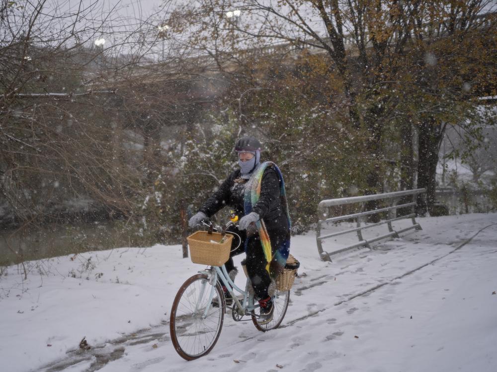 Houston, Texas: A woman bikes along Buffalo Bayou in Eleanor Tinsley Park as winter storm Enzo brings heavy bands of snow and sleet on Jan. 21.
