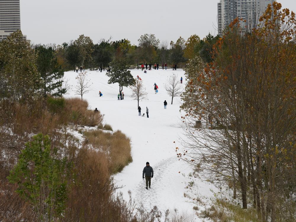 Houston, Texas: Pedestrians walk through the snow at Buffalo Bayou during a winter storm on Tuesday, Jan. 21.