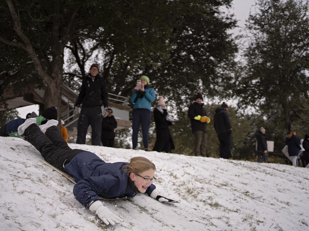 Houston, Texas: Vivian West sleds along the hills of Eleanor Tinsley Park as winter storm Enzo brings heavy bands of snow and sleet on Jan. 21.