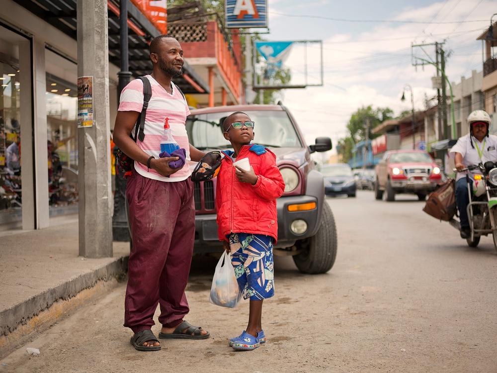 Didier Betofe, from the Congo, Africa, and his 6-year-old son clean windshields and beg for money in the Mexican town of Ciudad Acuña across from Roma, Texas.   Didier arrived in Ecuador and traveled north to Ciudad Acuña, where they have been living the past three months.