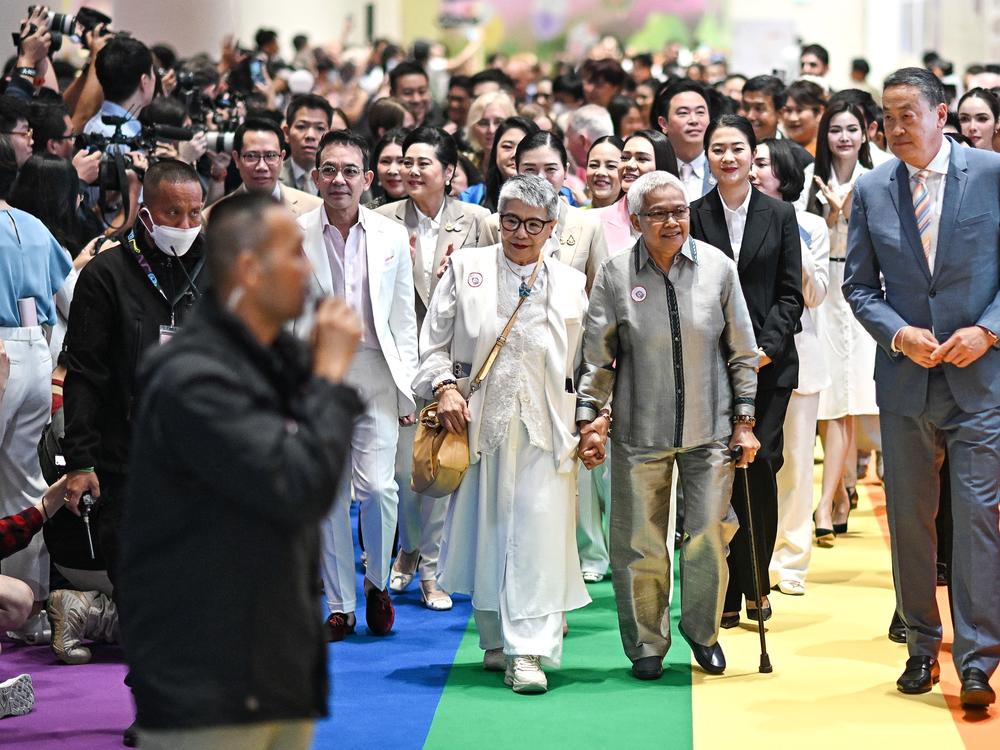 Thailand's former prime minister Srettha Thavisin (R) arrives with same-sex couples at a marriage registration event at Paragon shopping mall in Bangkok on Thursday.