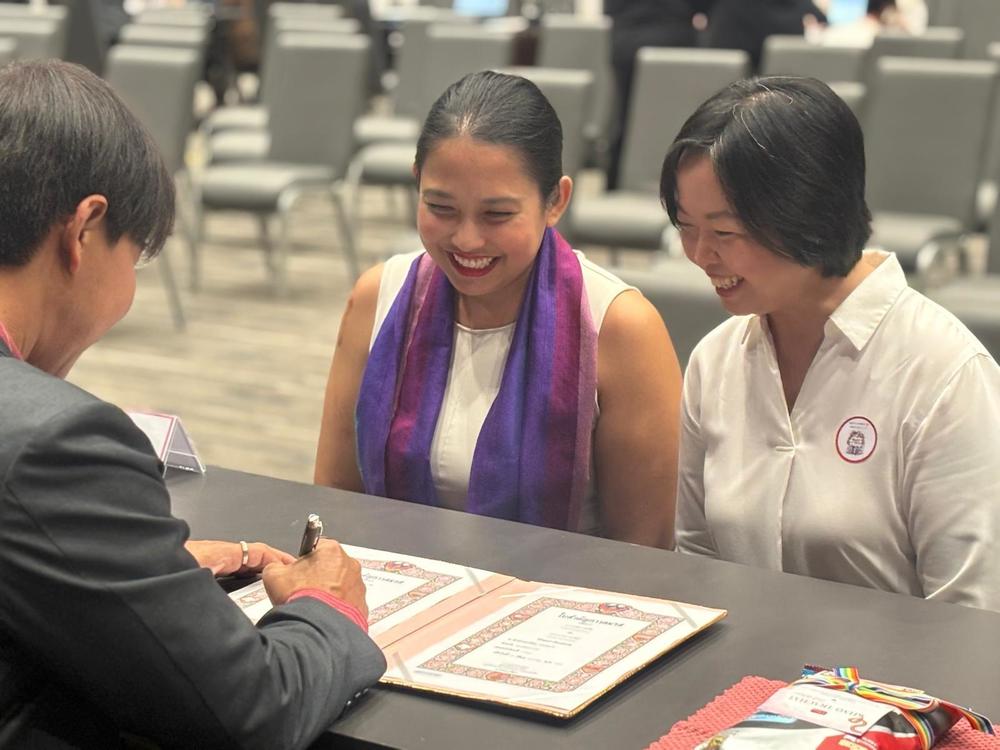 Anticha Sangchai and Vorawan Ramwan witness the signing of their marriage certificate in Bangkok, Thailand, on Thursday.