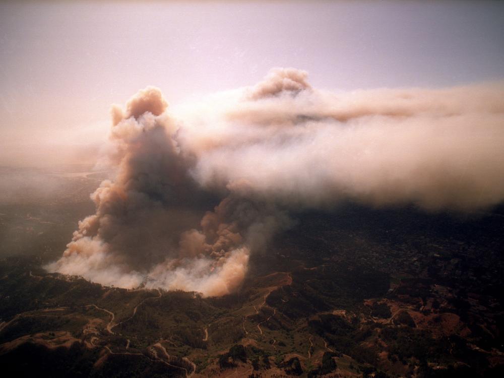 The Oakland Hills fire burned thousands of homes and created a dust cloud that could be seen for miles. Picture taken on Oct. 20, 1991.<br>