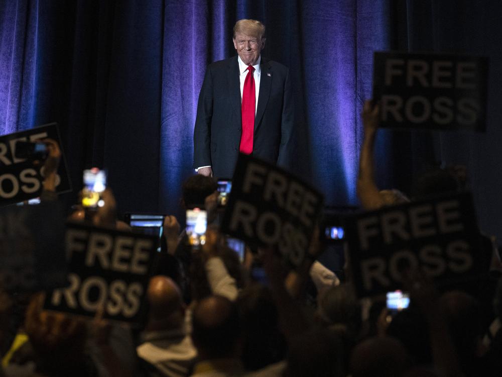 People hold up signs reading 