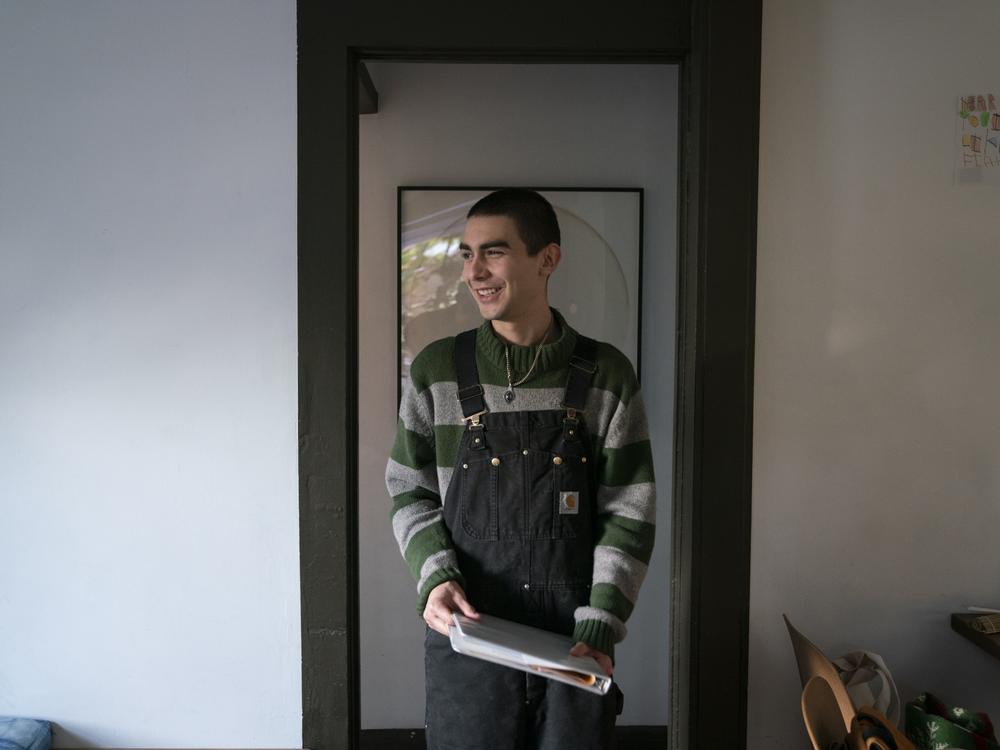 Pedro holds his biology homework. The binder of papers is one of the few things he brought with him while evacuating. He later learned that his home and most of his possessions were lost to the fire. He's been cobbling together his outfits with some winter clothes he packed.