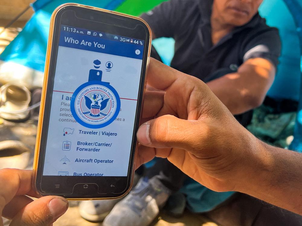 A migrant at the U.S.-Mexico border shows the CBP One App from the U.S. Customs and Border Protection agency that is used to apply for an appointment to apply for asylum.