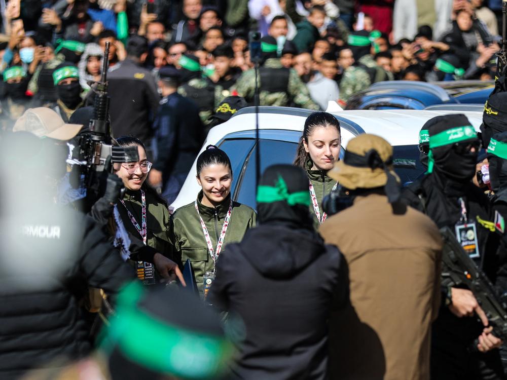 Hamas fighters escort four Israeli hostages to hand them over to a team from the Red Cross in Gaza City on January 25, 2025.