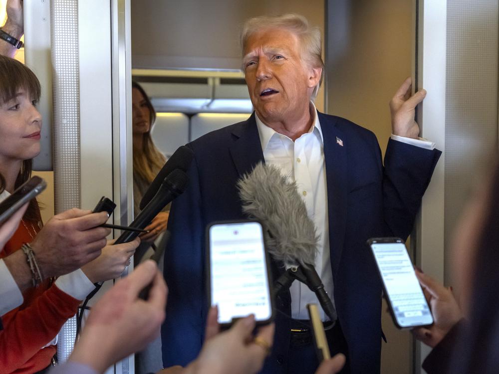 President Donald Trump speaks to reporters aboard Air Force One as he travels from Las Vegas to Miami, on Saturday.