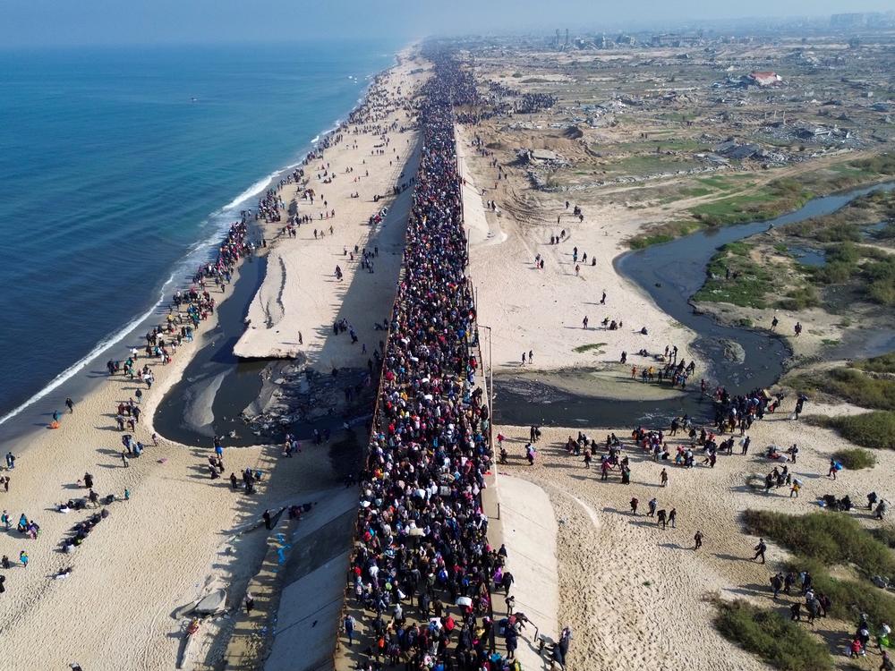 This aerial photo shows displaced Gazans walking toward Gaza City on Jan. 27, 2025, after crossing the Netzarim corridor from the southern Gaza Strip.