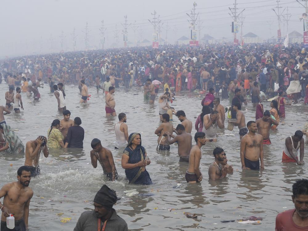 Hindu devotees take a holy dip by the banks of the Sangam, the confluence of the Ganges, the Yamuna and the mythical Saraswati rivers, on 