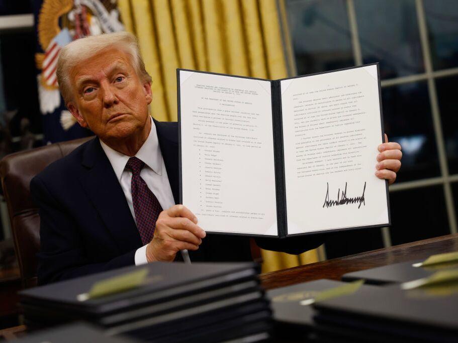 President Trump signs executive orders in the Oval Office on Jan. 20.