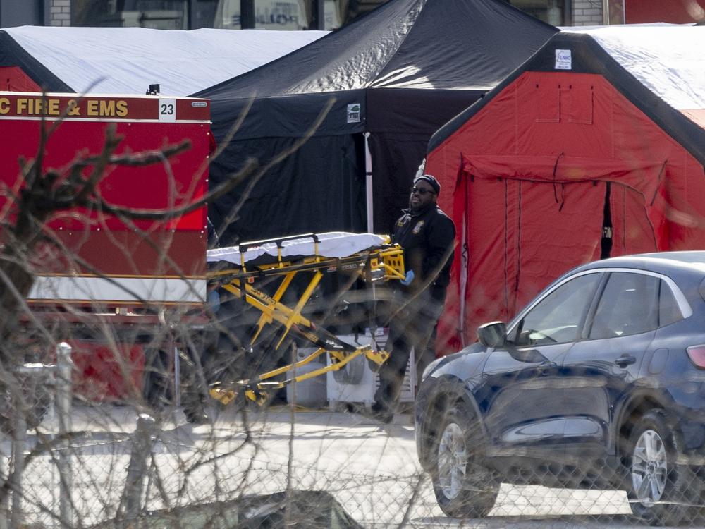 Emergency workers carry a stretcher at a makeshift morgue set up near Audi Field in Washington, D.C., on Thursday.