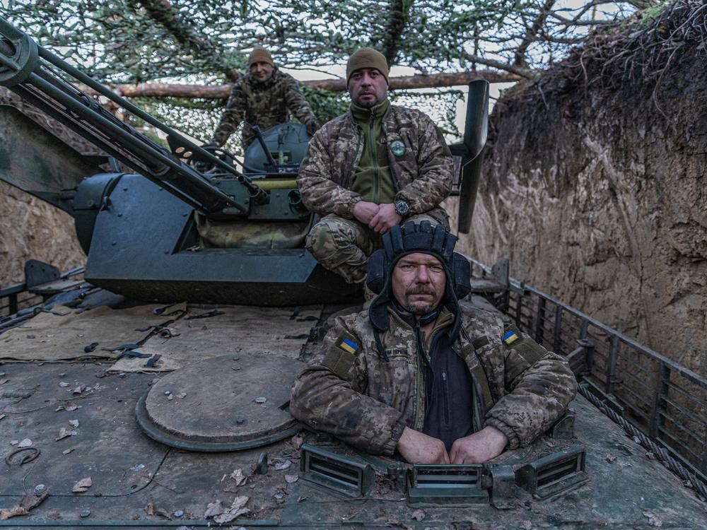 A driver-mechanic with the call sign Molfar (right), the unit's leader call-signed Grizzly (center) and a gunner with the call sign Psycho are on a BMP-1, a modernized Soviet-era infantry fighting vehicle, before a mission to the coast of Dnipro River in Ukraine's Kherson region on Jan. 4.