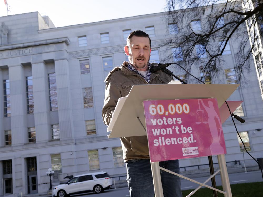 Standing in front of the North Carolina Supreme Court in Raleigh on Jan. 14, Ted Corcoran reads a list of over 60,000 people who cast ballots in the November 2024 election but whose votes have been challenged by Republican court candidate Jefferson Griffin in his extremely close race with Democratic Justice Allison Riggs.