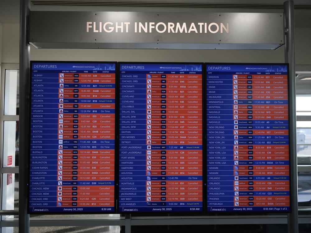 A flight information board shows cancelled flights at the Reagan National Airport. Operations at the airport are expected to restart at 11 a.m. EST.