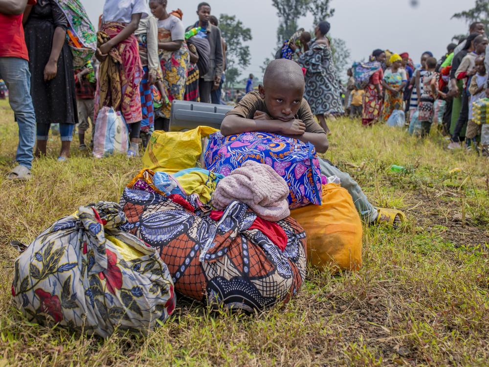 People who crossed from Congo wait for assistance in Gyseny, Rwanda, on Tuesday, following M23 rebels' advances into eastern Congo's capital Goma.
