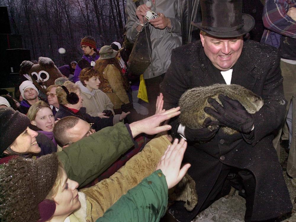 Punxsutawney Phil, seen here in 2001 being carried by Groundhog Club Inner Circle member William Deeley, has been making weather predictions on Gobbler's Knob in Punxsutawney, Pa., since the late 1880s.