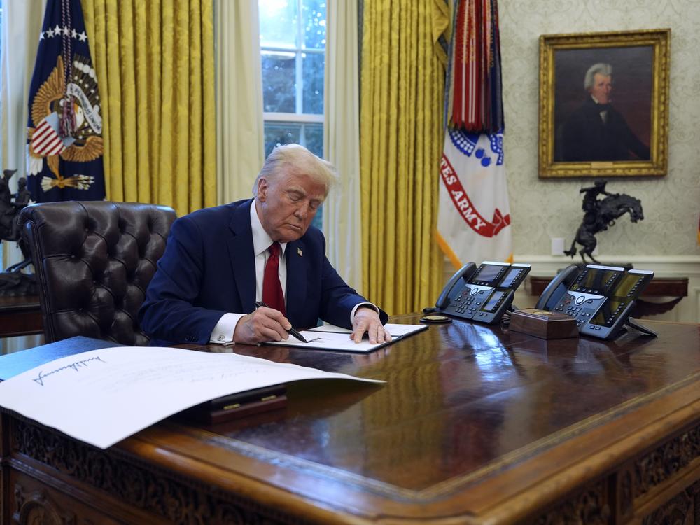 President Trump signs executive orders in the Oval Office at the White House,  Jan. 30.