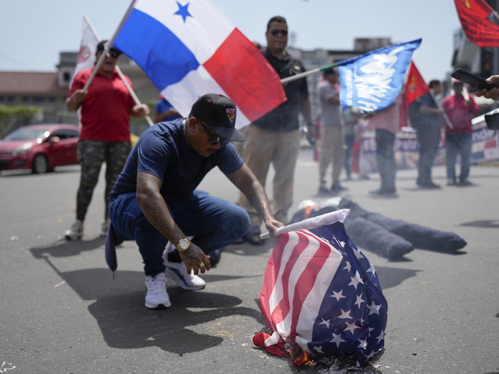 A demonstrator burns a U.S. flag to protest the upcoming visit of U.S. Secretary of State Marco Rubio in Panama City, Friday, Jan. 31, 2025