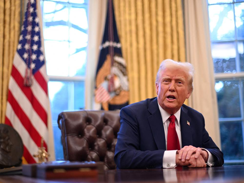 President Trump speaks to journalists in the Oval Office on Friday. A federal judge in Rhode Island has issued an order blocking the administration's efforts to freeze some federal spending.