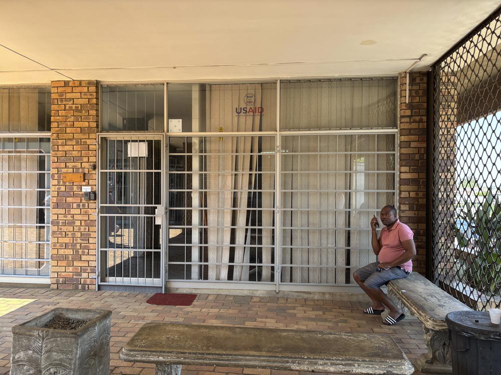 A man sits outside the closed Isizinda Sempilo clinic in the Johannesburg township of Soweto Thursday, Jan. 30.