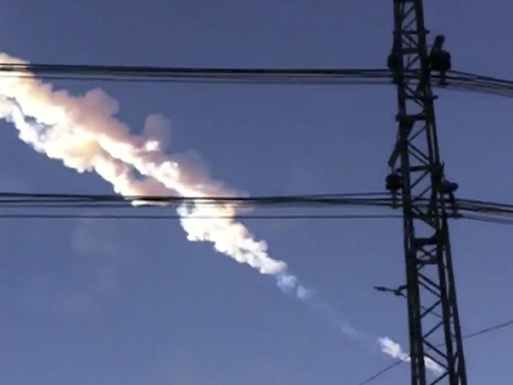 A meteor contrail is seen over Chelyabinsk, Russia on Friday, Feb. 15, 2013, in a photo taken by a mobile phone camera. The object streaked across the sky over Russia's Ural Mountains region causing a shock wave and injuring hundreds of people, including many who were hurt by broken glass.