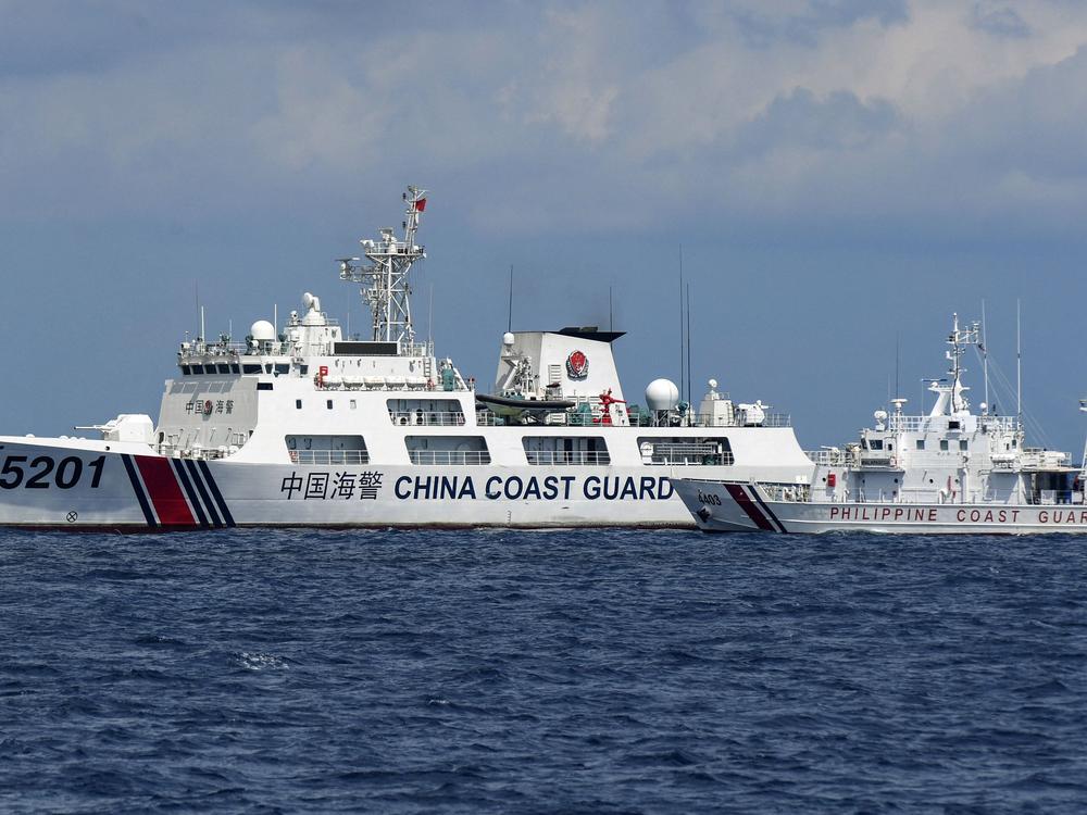 A Philippine coast guard vessel maneuvers as a Chinese coast guard ship cuts its path in the disputed South China Sea in 2023.