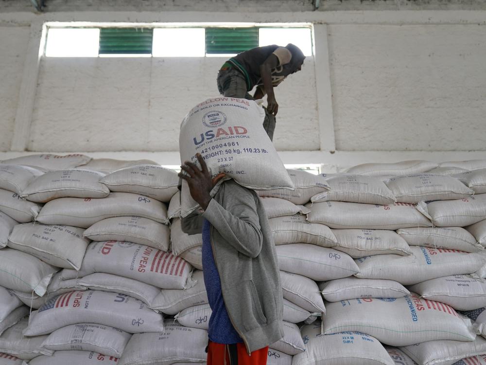 Workers move bags of yellow lentils at an aid operation run by USAID, Catholic Relief Services and the Relief Society of Tigray in Mekele, Ethiopia, on June 16, 2021.