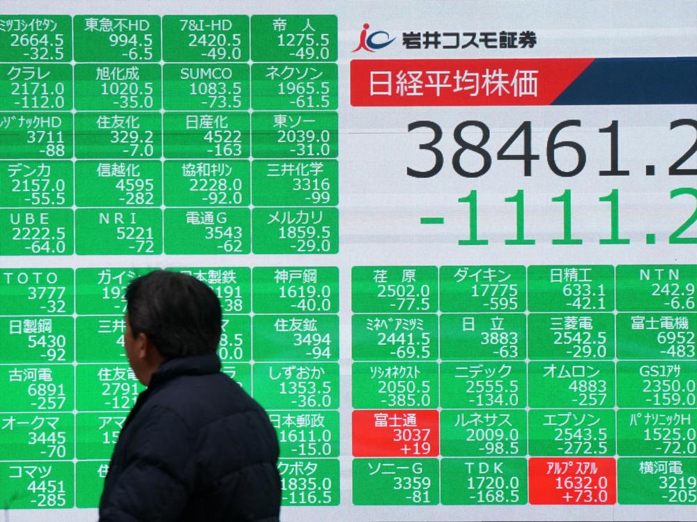 A man looks at the electronic board showing the numbers of the Nikkei Stock Average on the Tokyo Stock Exchange on a street in central Tokyo on February 3, 2025.