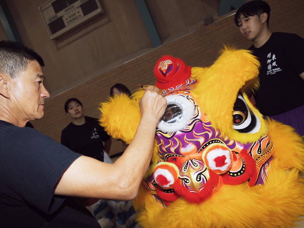 A lion's body is dotted with water, a part of the awakening act along with dotting the eyes and horn, at East Wind's headquarters in LA in August 2024.