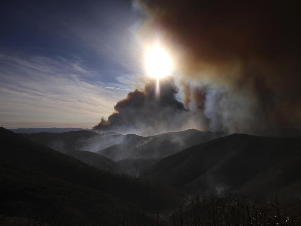 The Hughes Fire causes plumes of smoke over a mountainous area of Castaic, CA, Wednesday, Jan. 22, 2025.  That smoke traveled to nearby Ventura County where around 40,000 farmworkers labor in nearby fields.