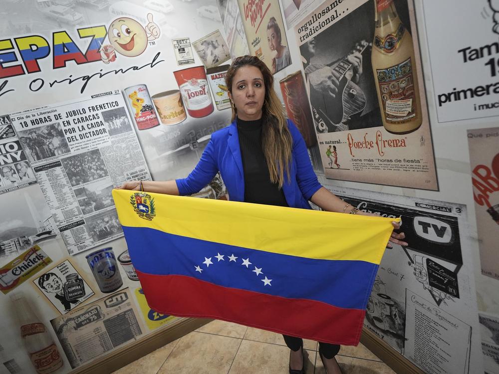 Mariana Molero, 44, holds a Venezuelan flag with seven stars as she poses for a picture following a press conference by Venezuelan community leaders to denounce changes to the protections that shielded hundreds of thousands of Venezuelans, including Molero, from deportation.