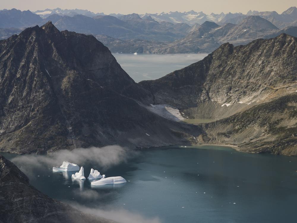Icebergs are photographed from the window of an airplane carrying NASA scientists as they fly on a mission to track melting ice in eastern Greenland on Aug. 14, 2019.