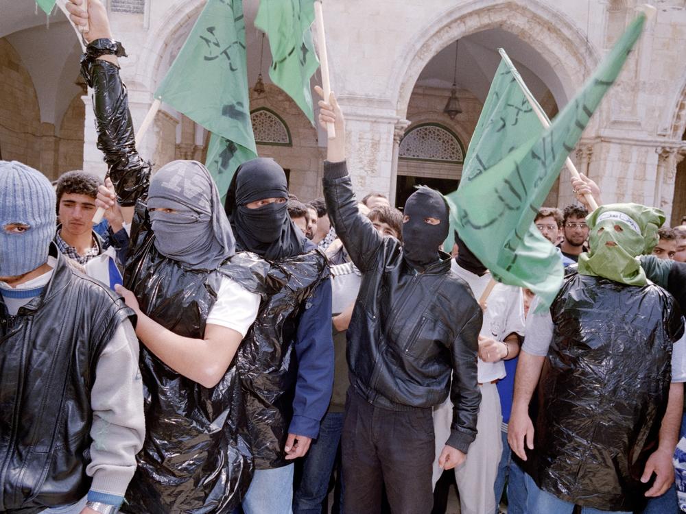 Masked Palestinians from Hamas march with the Hamas flag in front of the Al Aqsa Mosque in Jerusalem's Old City in 1987.