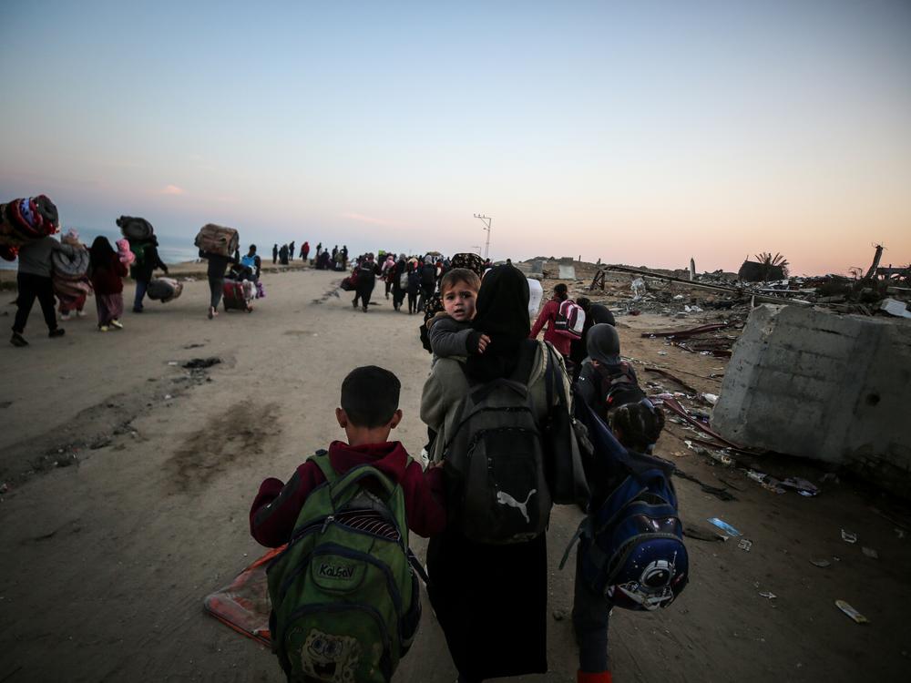 Displaced Palestinians make their way back on foot from the southern Gaza regions to their homes in the north via Al Rashid Road after the ceasefire agreement, Jan. 28.
