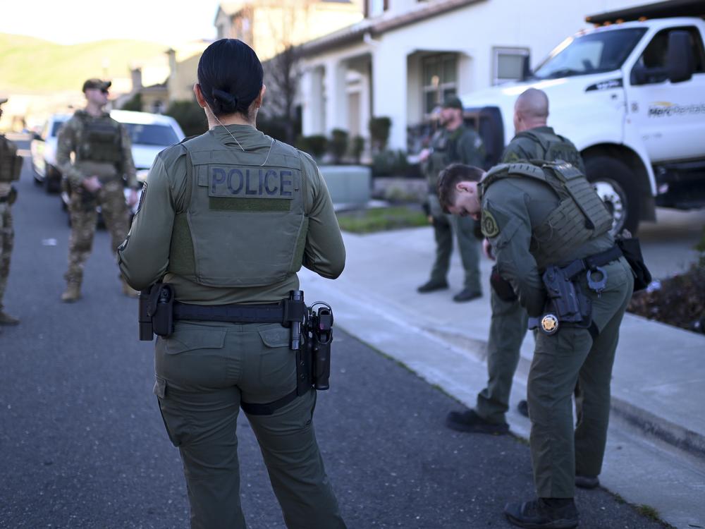 The Law Enforcement Division of California's Department of Cannabis Control waits outside of one of the three private residences raided for unlicensed marijuana production.
